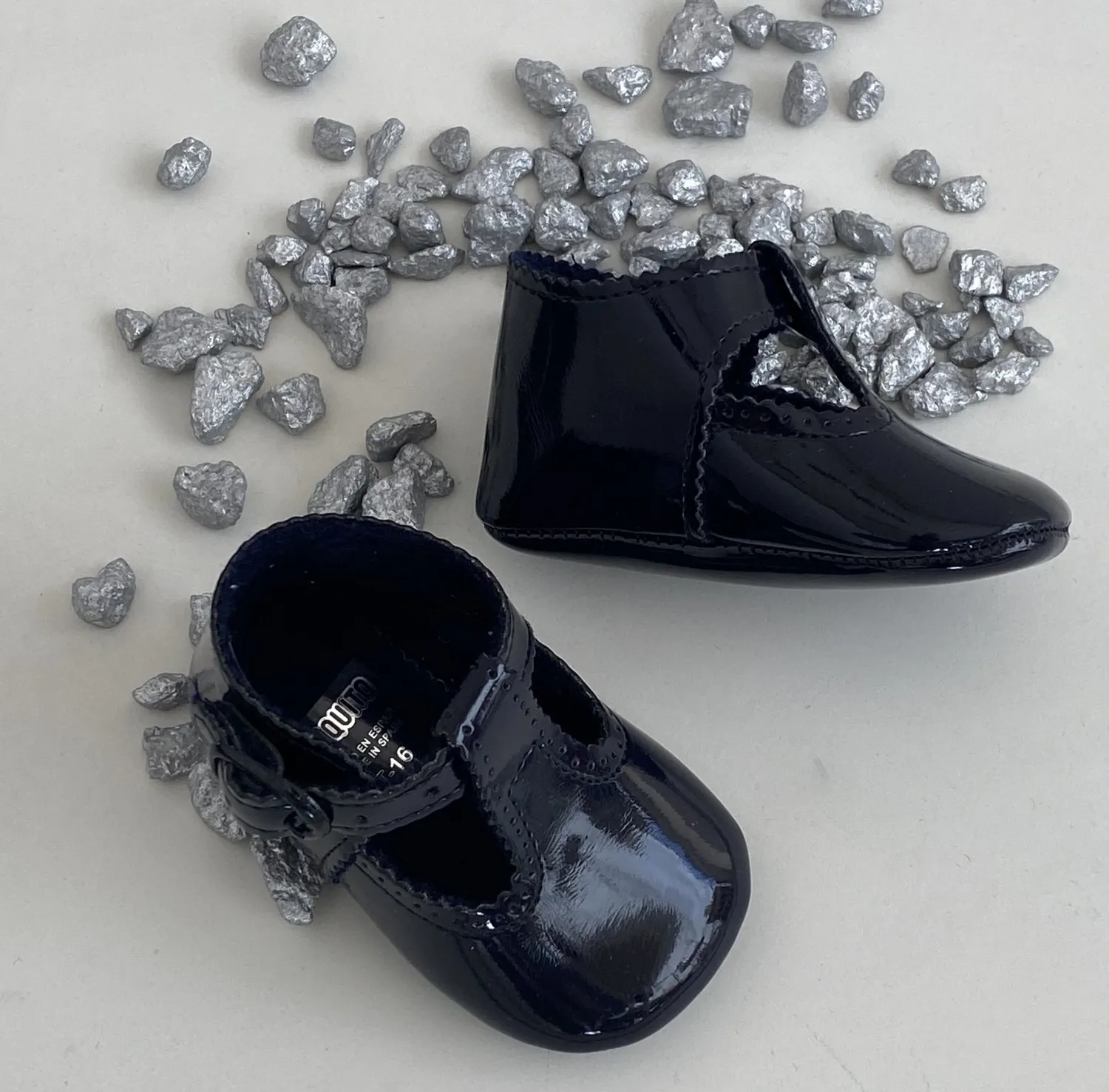 Baby shoe in light white or navy patent leather.